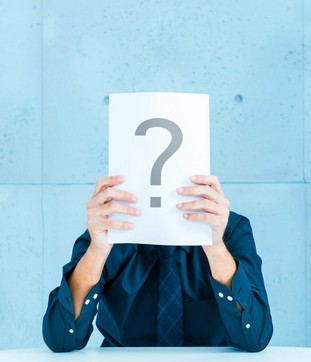 Frau hält Fragezeichen vor ihr Gesicht - Selbstzweifel www.simply-good-coaching.de