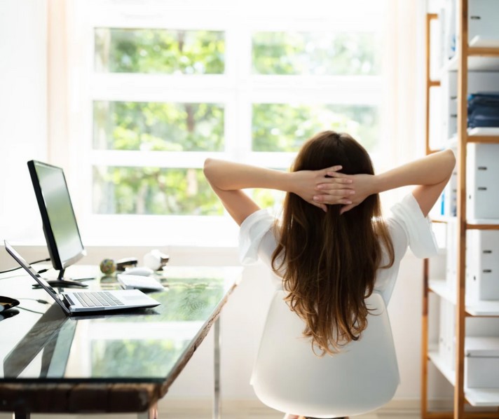 Frau sitzt entspannt am Schreibtisch und macht eine Erholungspause - www.simply-good-coaching.de Blogartikel